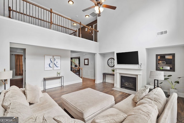 2767 NW Magnolia Creek Dr, Kennesaw, GA 30152 - living room featuring a towering ceiling, stairway, ceiling fan, wood finished floors, and a fireplace with flush hearth