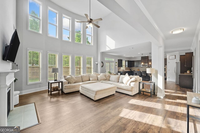 2767 NW Magnolia Creek Dr, Kennesaw, GA 30152 - living room with ceiling fan, hardwood / wood-style flooring, a fireplace with flush hearth, a high ceiling, and crown molding