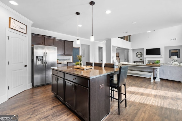2767 NW Magnolia Creek Dr, Kennesaw, GA 30152 - kitchen with stainless steel fridge with ice dispenser, a breakfast bar area, crown molding, dark wood-type flooring, and dark stone countertops
