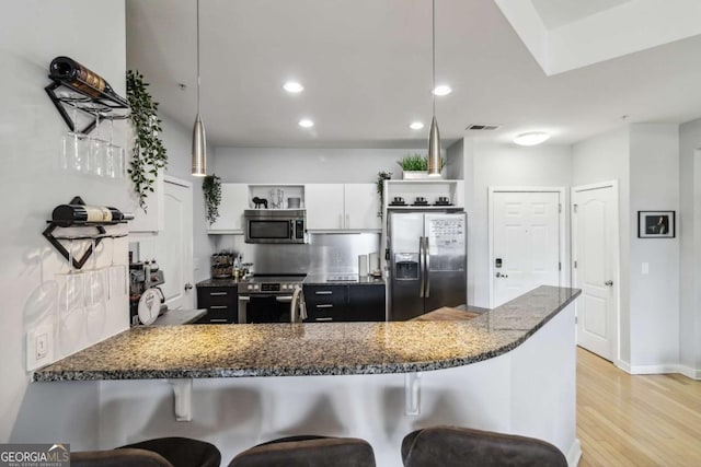 390 17th St NW Unit 6055, Atlanta, GA 30363 - kitchen featuring stainless steel appliances, open shelves, a kitchen bar, dark stone counters, and a peninsula