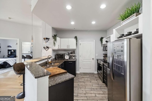 390 17th St NW Unit 6055, Atlanta, GA 30363 - kitchen with appliances with stainless steel finishes, a peninsula, open shelves, white cabinetry, and light wood finished floors