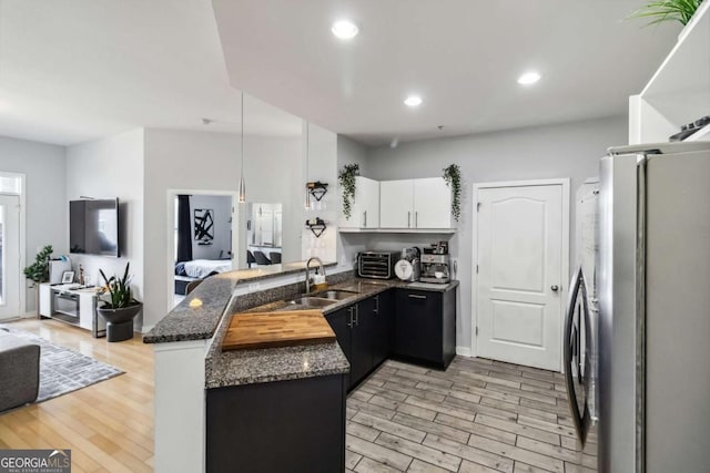 390 17th St NW Unit 6055, Atlanta, GA 30363 - kitchen with freestanding refrigerator, a peninsula, light wood finished floors, dark stone countertops, and recessed lighting
