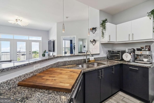 390 17th St NW Unit 6055, Atlanta, GA 30363 - kitchen featuring white cabinetry, dark stone counters, pendant lighting, french doors, and dishwashing machine