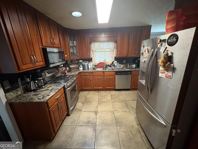 2119 Amherst Trl SE, Conyers, GA 30094 - kitchen featuring stainless steel appliances, stone counters, glass insert cabinets, and brown cabinetry