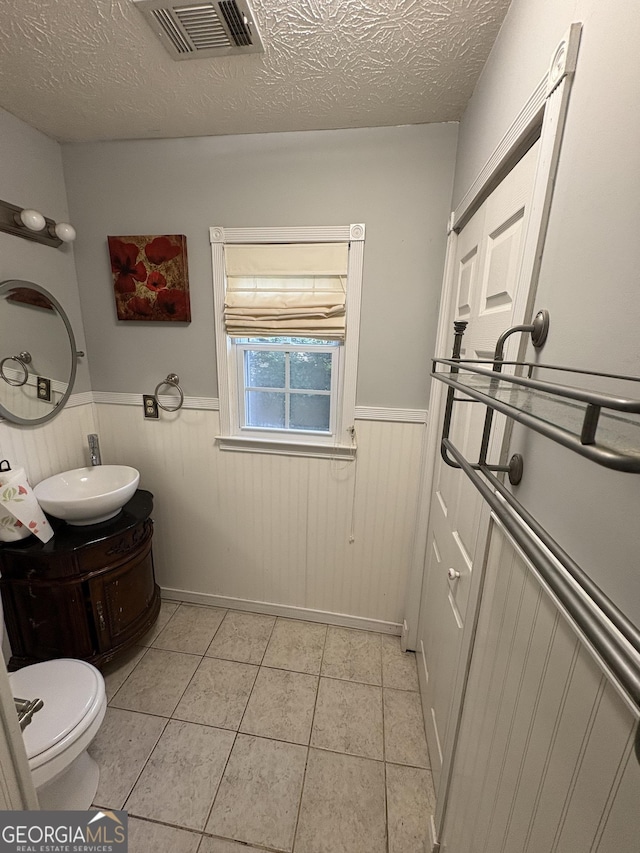 2119 Amherst Trl SE, Conyers, GA 30094 - bathroom featuring vanity, a wainscoted wall, tile patterned flooring, and a textured ceiling