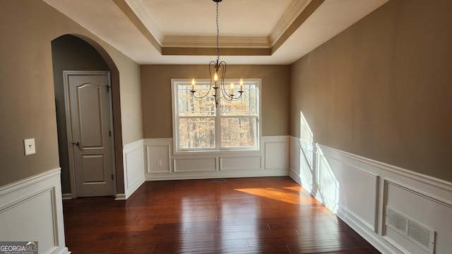 488 Morris Rd, Hiram, GA 30141 - unfurnished dining area featuring dark wood-type flooring, a raised ceiling, crown molding, a chandelier, and arched walkways