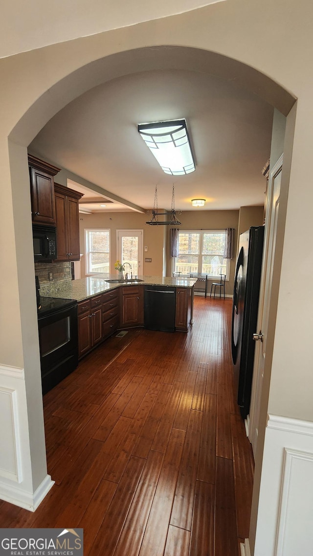 488 Morris Rd, Hiram, GA 30141 - kitchen featuring black appliances, arched walkways, dark wood finished floors, a peninsula, and wainscoting