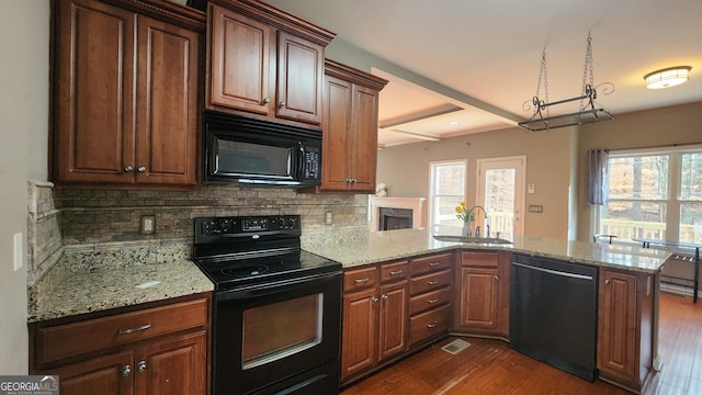 488 Morris Rd, Hiram, GA 30141 - kitchen with black appliances, a peninsula, dark wood-type flooring, decorative backsplash, and light stone countertops