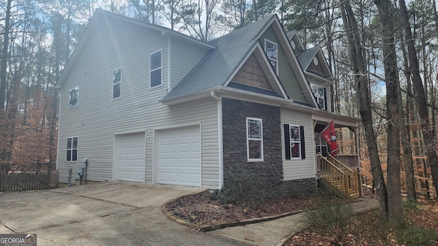 488 Morris Rd, Hiram, GA 30141 - view of home's exterior with stone siding, concrete driveway, a garage, and roof with shingles