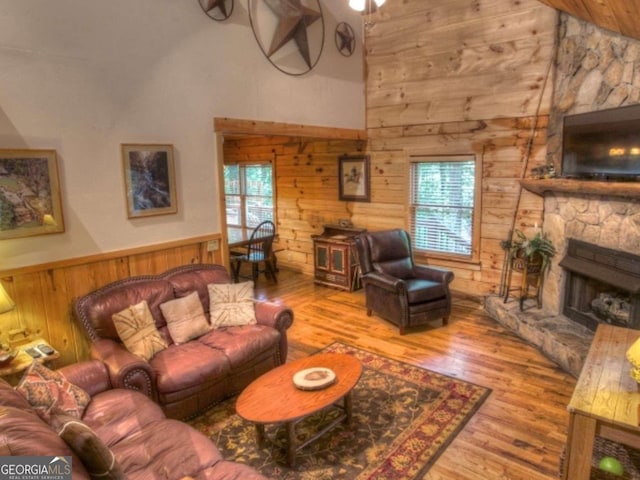 97 Eagles Nest Rd, Sautee Nacoochee, GA 30571 - living room featuring wood walls, high vaulted ceiling, wood finished floors, plenty of natural light, and a fireplace
