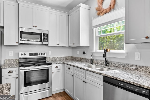 481 Hunter Welch Pkwy, Luthersville, GA 30251 - kitchen with stainless steel appliances, white cabinets, light stone counters, and wood finished floors