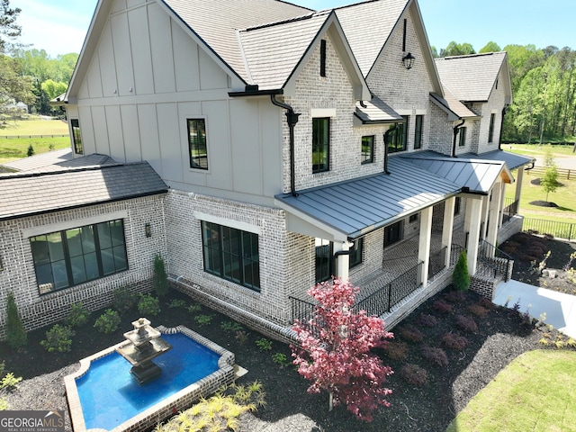 1005 Haddie Way, Alpharetta, GA 30004 - back of house with board and batten siding, brick siding, a standing seam roof, and a porch