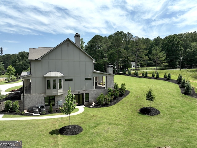 1005 Haddie Way, Alpharetta, GA 30004 - view of side of property with a chimney, board and batten siding, a yard, and brick siding