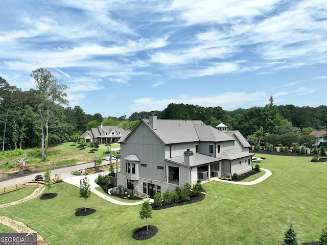 1005 Haddie Way, Alpharetta, GA 30004 - rear view of house featuring a chimney, a lawn, and view of wooded area