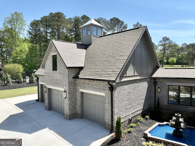 1005 Haddie Way, Alpharetta, GA 30004 - view of home's exterior featuring brick siding, driveway, an attached garage, and board and batten siding