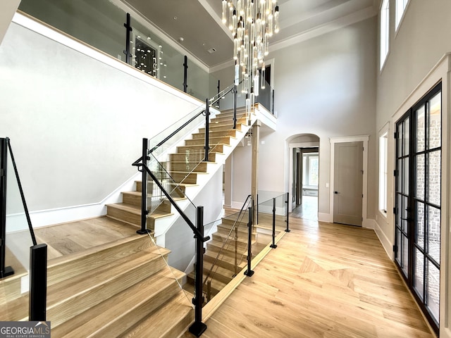 1005 Haddie Way, Alpharetta, GA 30004 - foyer featuring arched walkways, a towering ceiling, wood finished floors, and stairs