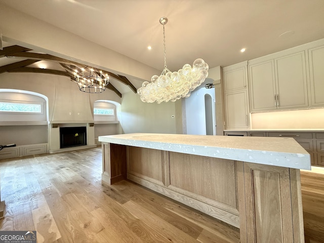 1005 Haddie Way, Alpharetta, GA 30004 - kitchen featuring arched walkways, a chandelier, light countertops, light wood-style floors, and a kitchen island