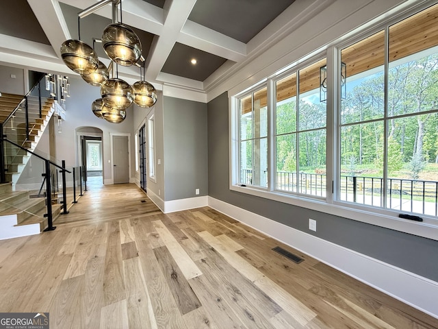1005 Haddie Way, Alpharetta, GA 30004 - unfurnished dining area with arched walkways, stairway, coffered ceiling, plenty of natural light, and beamed ceiling