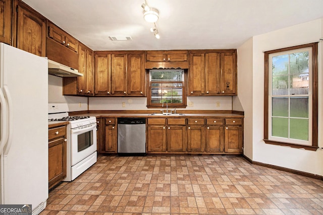 4214 Fiddlers Bnd, Loganville, GA 30052 - kitchen with white appliances, brown cabinets, under cabinet range hood, and brick patterned floors