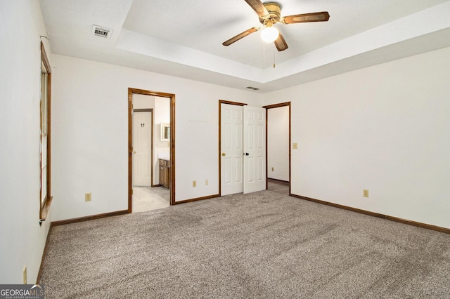 4214 Fiddlers Bnd, Loganville, GA 30052 - unfurnished bedroom featuring light carpet, a tray ceiling, ensuite bath, and ceiling fan