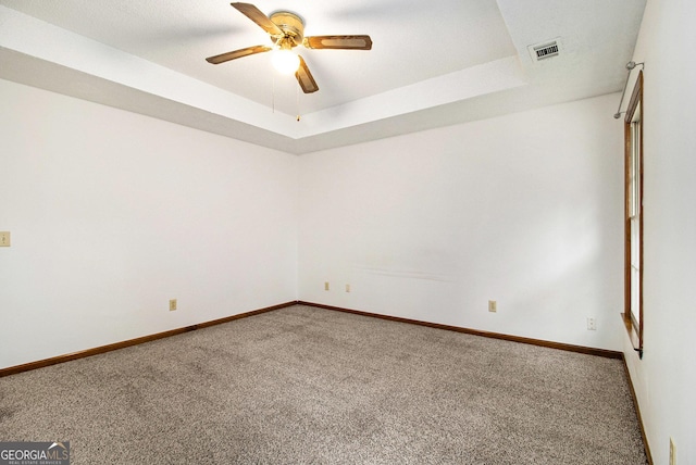 4214 Fiddlers Bnd, Loganville, GA 30052 - spare room featuring carpet floors, ceiling fan, and a tray ceiling