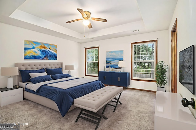 4214 Fiddlers Bnd, Loganville, GA 30052 - bedroom featuring a tray ceiling, multiple windows, ceiling fan, and carpet