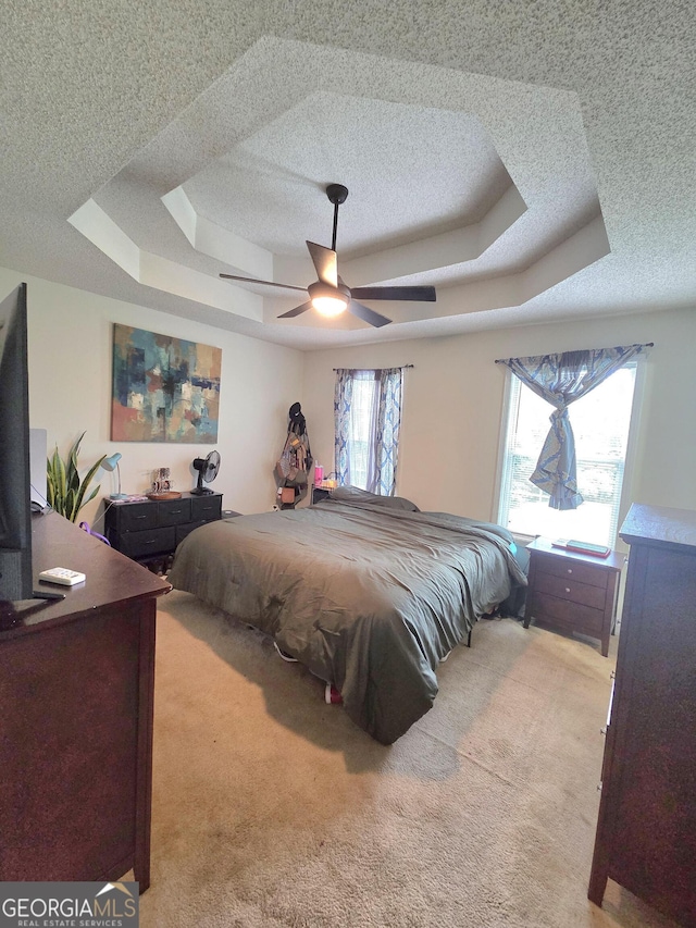 165 Cedar Ridge Rd, Locust Grove, GA 30248 - bedroom with a tray ceiling, light colored carpet, a textured ceiling, and a ceiling fan