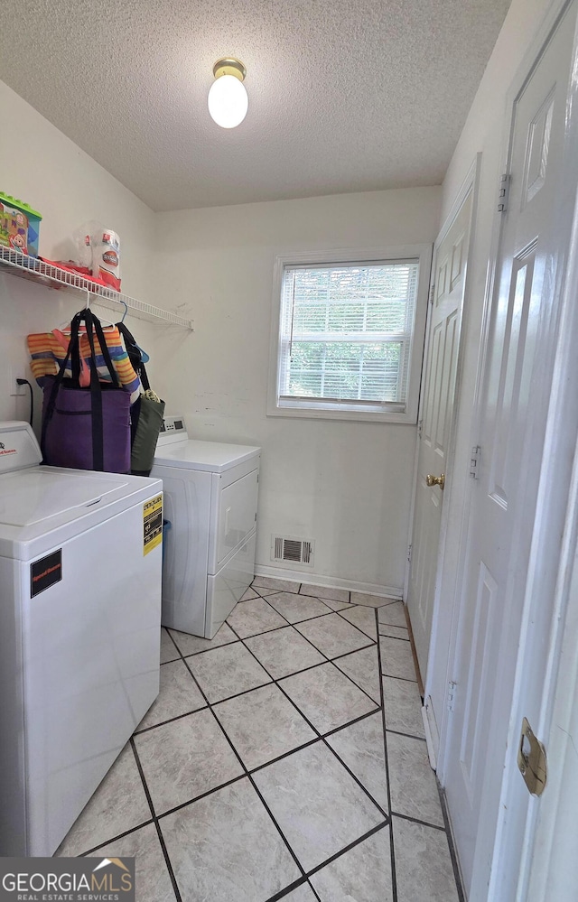165 Cedar Ridge Rd, Locust Grove, GA 30248 - laundry area featuring independent washer and dryer, a textured ceiling, and light tile patterned flooring