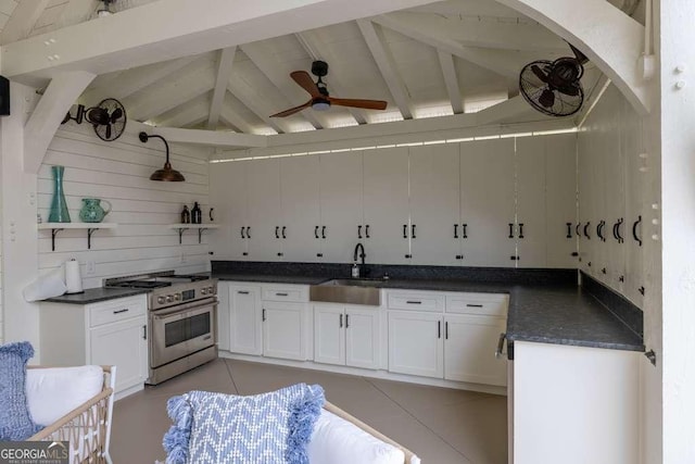 481 Meadow Lake Ter, Hoschton, GA 30548 - kitchen with high end stainless steel range oven, dark countertops, open shelves, a ceiling fan, and white cabinetry