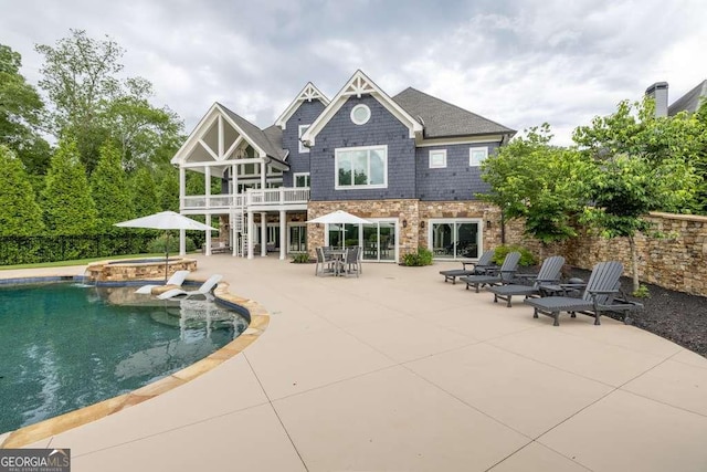 481 Meadow Lake Ter, Hoschton, GA 30548 - rear view of house with a patio, a balcony, a pool with connected hot tub, and stone siding