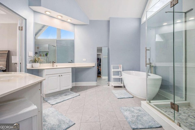 2275 Holly Run Dr, Jonesboro, GA 30236 - full bath with two vanities, a freestanding bath, a shower stall, high vaulted ceiling, and recessed lighting