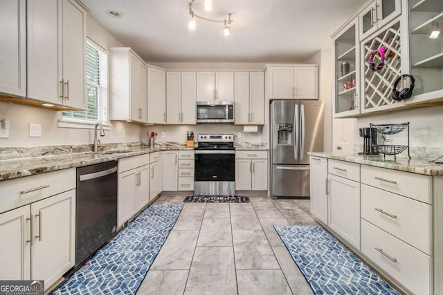 2275 Holly Run Dr, Jonesboro, GA 30236 - kitchen featuring stainless steel appliances, light stone counters, glass insert cabinets, and white cabinetry