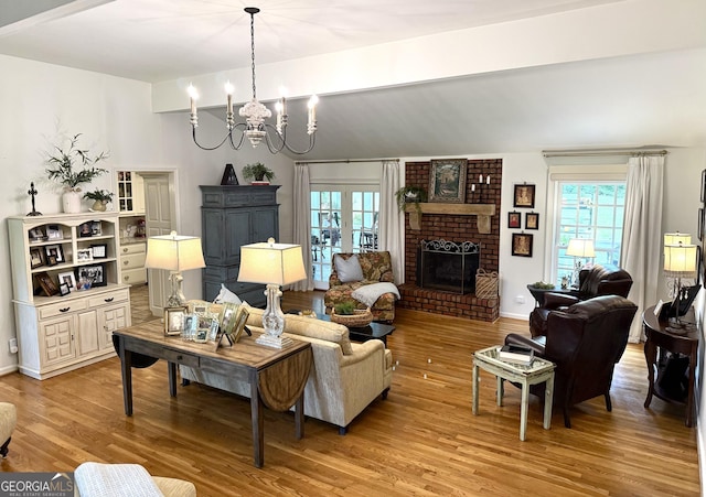 1055 E Hermitage Rd NE, Rome, GA 30161 - living room featuring a chandelier, light wood-style flooring, a brick fireplace, and vaulted ceiling