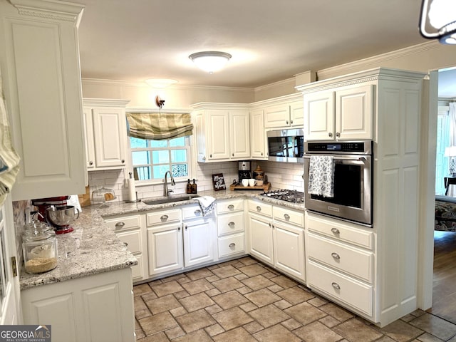 1055 E Hermitage Rd NE, Rome, GA 30161 - kitchen with appliances with stainless steel finishes, stone finish floors, decorative backsplash, crown molding, and white cabinetry