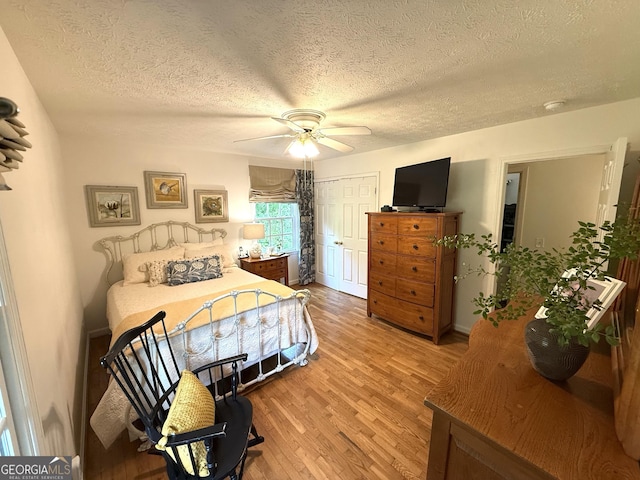 1055 E Hermitage Rd NE, Rome, GA 30161 - bedroom featuring a textured ceiling, light wood-style flooring, ceiling fan, and a closet