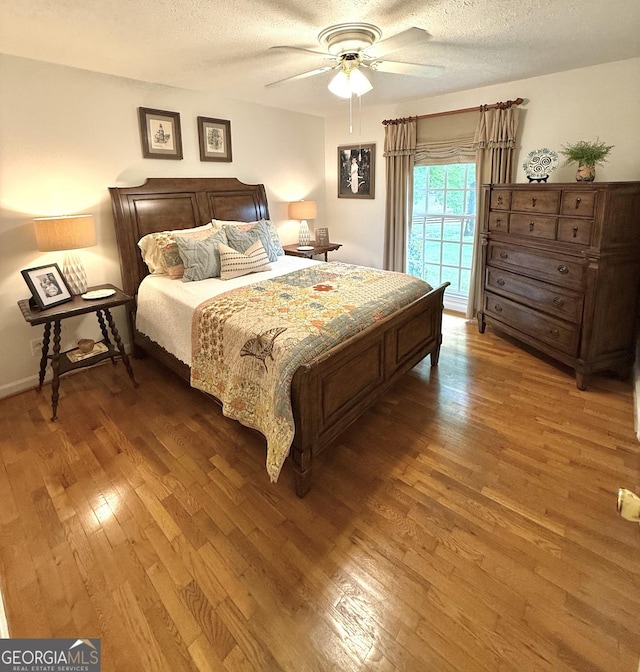 1055 E Hermitage Rd NE, Rome, GA 30161 - bedroom featuring light wood-style floors, a textured ceiling, and a ceiling fan