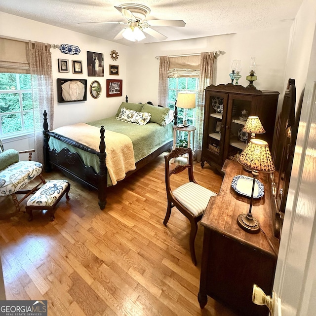 1055 E Hermitage Rd NE, Rome, GA 30161 - bedroom with light wood-style floors, a textured ceiling, and a ceiling fan