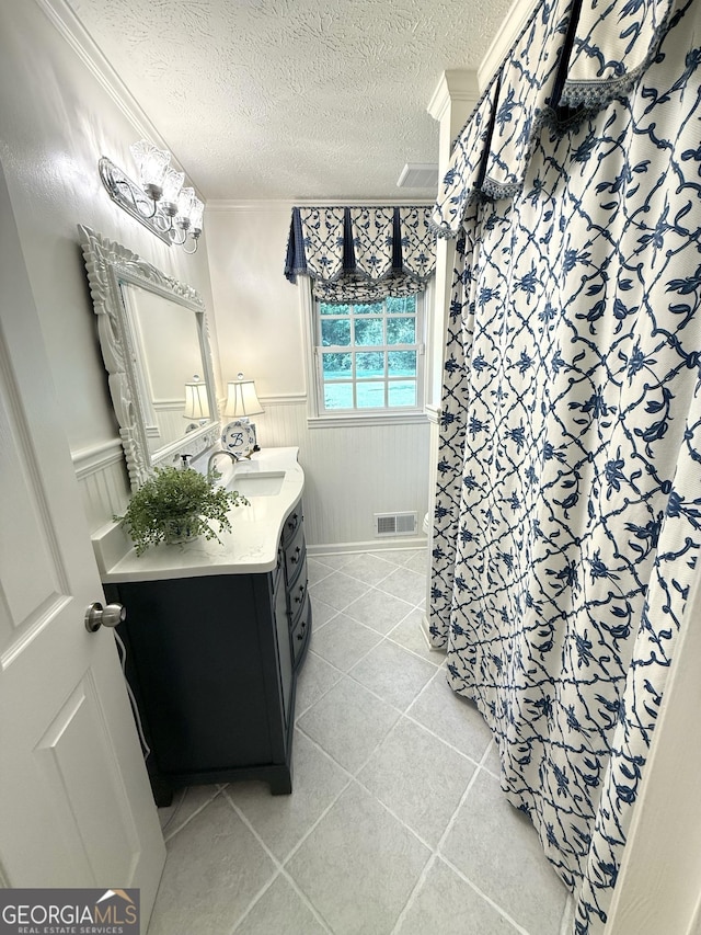 1055 E Hermitage Rd NE, Rome, GA 30161 - full bathroom with vanity, a textured ceiling, a wainscoted wall, ornamental molding, and tile patterned flooring