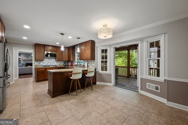 3912 Edenton Ct, Brookhaven, GA 30319 - kitchen featuring appliances with stainless steel finishes, ornamental molding, a peninsula, backsplash, and a breakfast bar area