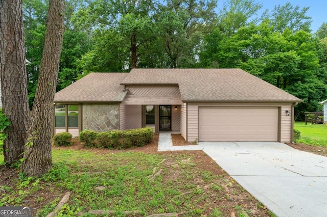 4818 Terrace Green Trce, Stone Mountain, GA 30088 - mid-century modern home with a garage, driveway, roof with shingles, and stone siding