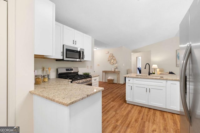 4818 Terrace Green Trce, Stone Mountain, GA 30088 - kitchen featuring stainless steel appliances, a peninsula, white cabinets, light wood finished floors, and light stone countertops