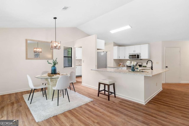 4818 Terrace Green Trce, Stone Mountain, GA 30088 - dining space featuring vaulted ceiling, light wood-style flooring, and a chandelier