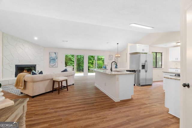 4818 Terrace Green Trce, Stone Mountain, GA 30088 - kitchen featuring stainless steel fridge with ice dispenser, open floor plan, lofted ceiling, white cabinetry, and light wood-style floors