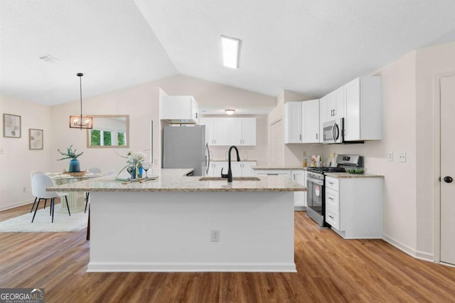 4818 Terrace Green Trce, Stone Mountain, GA 30088 - kitchen featuring appliances with stainless steel finishes, light stone counters, white cabinetry, vaulted ceiling, and light wood-style floors