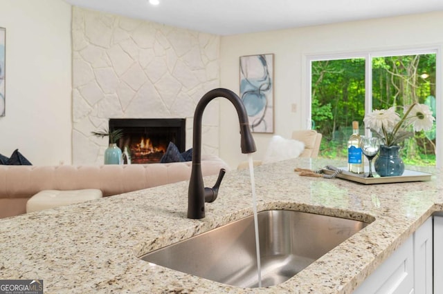 4818 Terrace Green Trce, Stone Mountain, GA 30088 - kitchen view of light stone counters, a fireplace, white cabinetry, and recessed lighting
