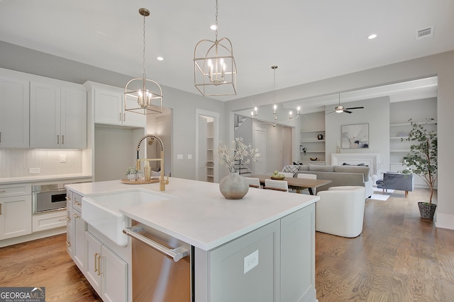 172 Forest Berry Ct Lot 100M2A, Newnan, GA 30265 - kitchen with appliances with stainless steel finishes, ceiling fan, light wood-style flooring, backsplash, and white cabinetry