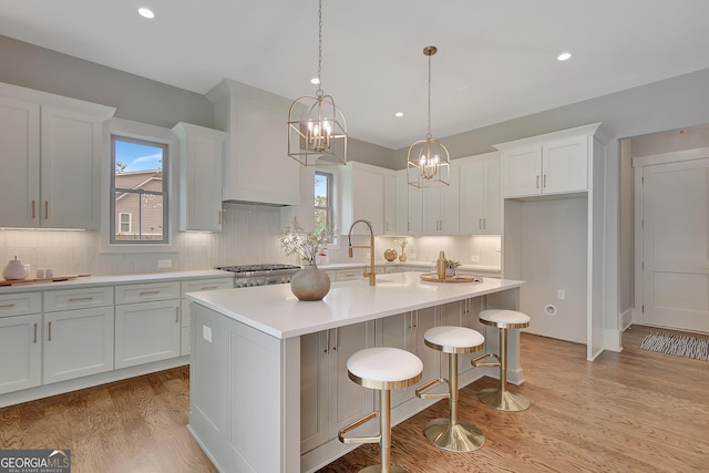 172 Forest Berry Ct Lot 100M2A, Newnan, GA 30265 - kitchen featuring light wood-type flooring, decorative backsplash, a chandelier, light countertops, and white cabinets
