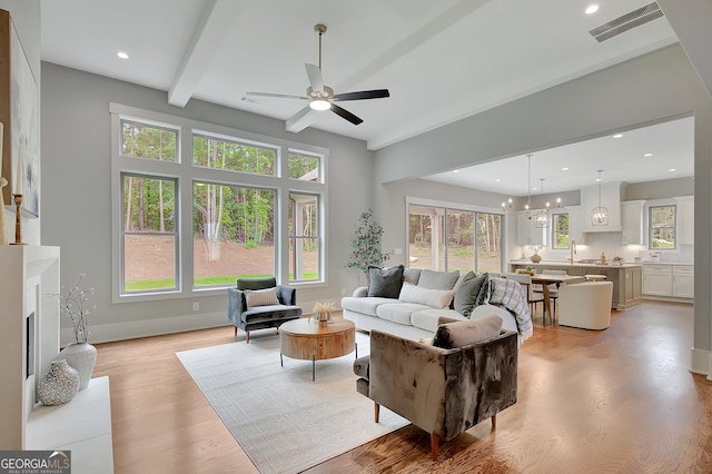 172 Forest Berry Ct Lot 100M2A, Newnan, GA 30265 - living room with a ceiling fan, plenty of natural light, light wood-style floors, a chandelier, and beam ceiling
