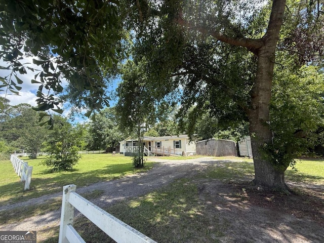 99 Conifer Dr, Guyton, GA 31312 - view of yard with dirt driveway and a storage shed