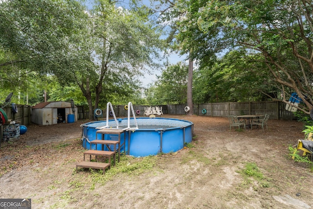 99 Conifer Dr, Guyton, GA 31312 - view of swimming pool with a fenced backyard, a shed, and view of wooded area